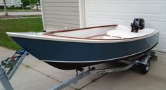 a blue and white boat parked in front of a garage