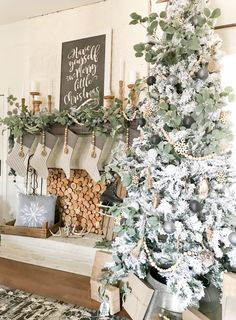 a decorated christmas tree with stockings hanging from it's sides in front of a fireplace