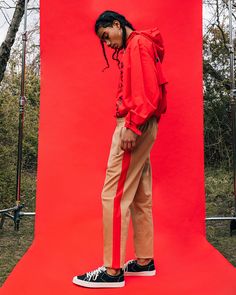 a person standing in front of a red backdrop