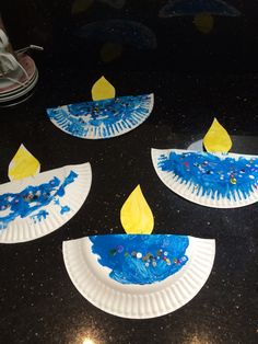 paper plates with blue and yellow designs on them sitting on a black countertop next to a pair of sneakers