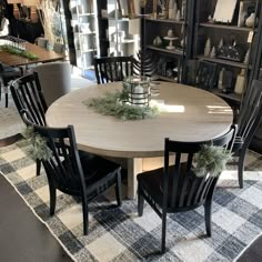 a dining room table with four chairs and a centerpiece on top of the table