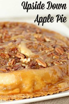 an upside down apple pie with pecans and caramel on top, sitting on a white plate