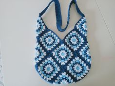 a crocheted blue and white purse sitting on top of a table