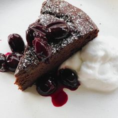 a piece of chocolate cake with whipped cream and cherries