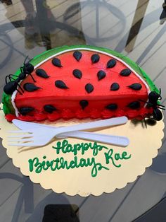 a watermelon cake with black dots on it and a fork in the middle