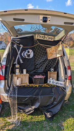 the back end of a car with its trunk open and fishing gear in it's cargo compartment