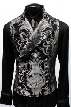 "An elegant double breasted vest for formal occasions. A fitted vest made in rich silver and black tapestry fabric with a stand up to collar and wide sweeping lapels. Fastens on the inside with a sturdy button and buttons on the outside with five engraved metal buttons. The vest back and inside lining is made from rich black satin. Comes in sizes small-XXXL. Wonderful! Measurements: Small: Chest 39\" Stomach 36\" Waist 34\" Medium: Chest 42\" Stomach 38\" Waist 36\" Large: Chest 44\" Stomach 42\ Vest Outfits Men, Black Tapestry, Steampunk Men, Fitted Vest, Double Breasted Vest, Engraved Metal, Tapestry Fabric, Fashion Suits For Men, Vest Outfits