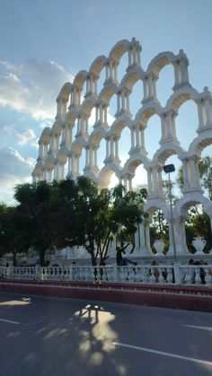 the sun shines brightly on an ornate white building with arches and pillars in front of it