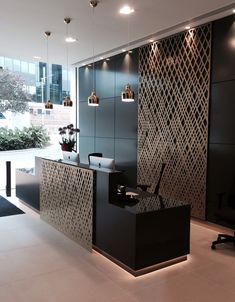 an office with black and white decor in the middle of the room is lit by recessed lights