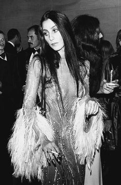 black and white photograph of woman in sequined dress with man standing behind her