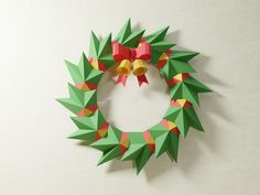 an origami christmas wreath with bells hanging on the wall