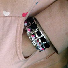 a pink and black bracelet with hearts on it