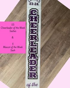 a banner with the word cheer written on it in white and purple letters, against a pink background