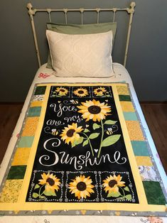 there is a quilt on the bed that says you are one sunshine and two sunflowers