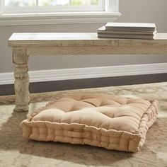 a white bench sitting in front of a window on top of a carpeted floor