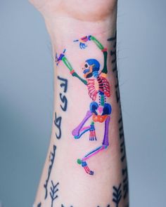 a person with a colorful skeleton tattoo on their arm