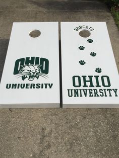 two white cornhole boards with the word ohio university on them sitting in front of a sidewalk