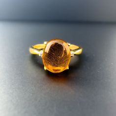 A beautiful and very unique 9ct yellow gold vintage amber & diamond ring featuring a deep honey coloured amber cabouchon on a raised cathedral prong setting flanked by 2 small diamonds on the uppper pinched  shoulders leading to a smooth rounded yellow gold band.  The ring is a UK Size P 1/2 - US Size 7.75 which can be resized a few sizes. Stamped 9K Please note before ordering if sizing is selected existing hallmarks are likely to be polished out  We cannot accept any refunds if sizing is selec Gold Oval Cabochon Topaz Ring Gift, Gold Oval Cabochon Topaz Ring, Gold Topaz Oval Cabochon Ring As Gift, Formal Amber Oval Cabochon Rings, Formal Amber 14k Gold Ring, Amber Oval Cabochon Rings, Oval Amber Cabochon Ring, Antique Amber Cabochon Rings, Gold Oval Cabochon Topaz Ring For Anniversary