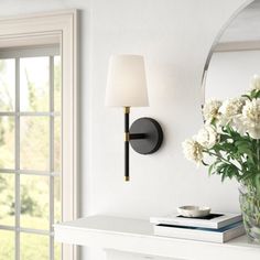 a vase filled with flowers sitting on top of a white table next to a mirror