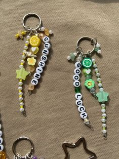 four different key chains with charms attached to them on a cloth covered surface, one has a star and the other has a lemon slice