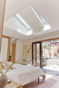 a bedroom with a large bed and skylights