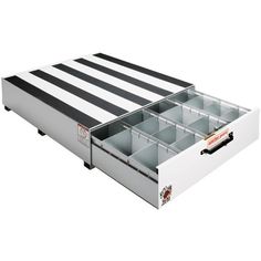 a white and black striped drawer with drawers in it's bottom compartment, on a white background