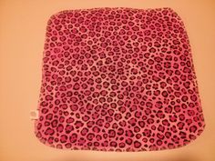 a pink and black animal print pillow on a wall