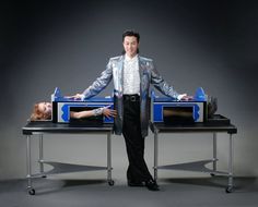 a man standing next to a woman on top of a table