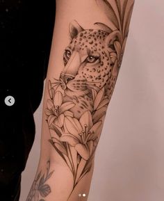 a woman's arm with a cheetah and flowers tattoo design on it