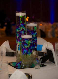 two tall vases filled with flowers on top of a table