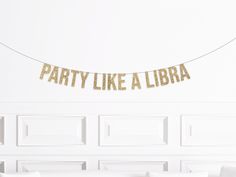 a party like a libra banner hanging from a string on a wall in a living room