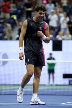 a man standing on top of a tennis court with a racquet in his hand