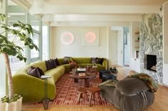 a living room filled with lots of furniture and a large tree in the middle of it