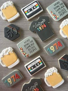 decorated cookies arranged in the shape of t - shirts and beer mugs on a table