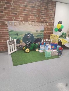 a farm themed birthday party with balloons and gifts on the floor in front of a brick wall