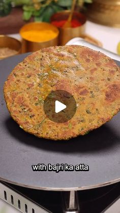 a pancake sitting on top of a stove next to a frying pan filled with food