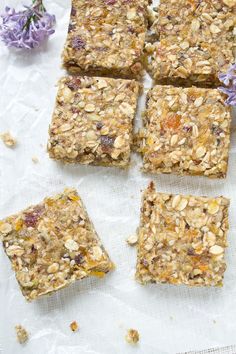 several squares of granola sitting on top of a piece of paper next to flowers