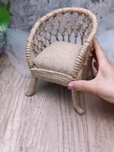 a miniature chair made out of rope on top of a wooden table