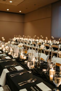 the tables are set with candles and place settings