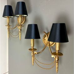 two wall lights with black shades on them