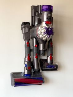 a silver and red robot sculpture sitting on top of a shelf next to a white wall