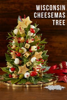 a christmas tree made out of cheeses and other holiday decorations on a wooden table