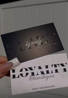 a person holding up two business cards that say, beauty and glammy on them