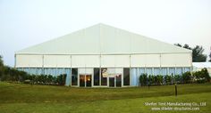 a large white building sitting on top of a lush green field