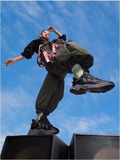 a person jumping in the air on top of speakers