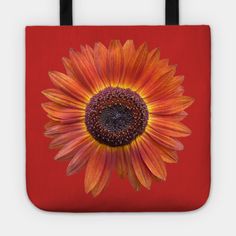 an orange and yellow sunflower on a red background tote bag with black handles