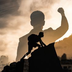 a silhouette of a man on top of a rock