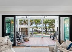 an open living room with sliding glass doors leading to the deck and pool area is shown