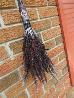 a broom hanging on the side of a brick building