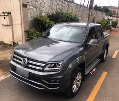 a grey volkswagen atlas parked in front of a building